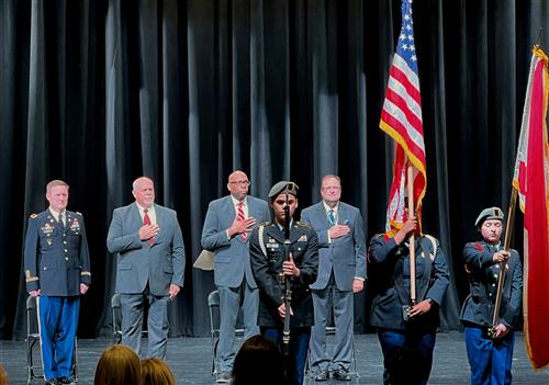 superintendents standing at attention for honor guard to post the flags